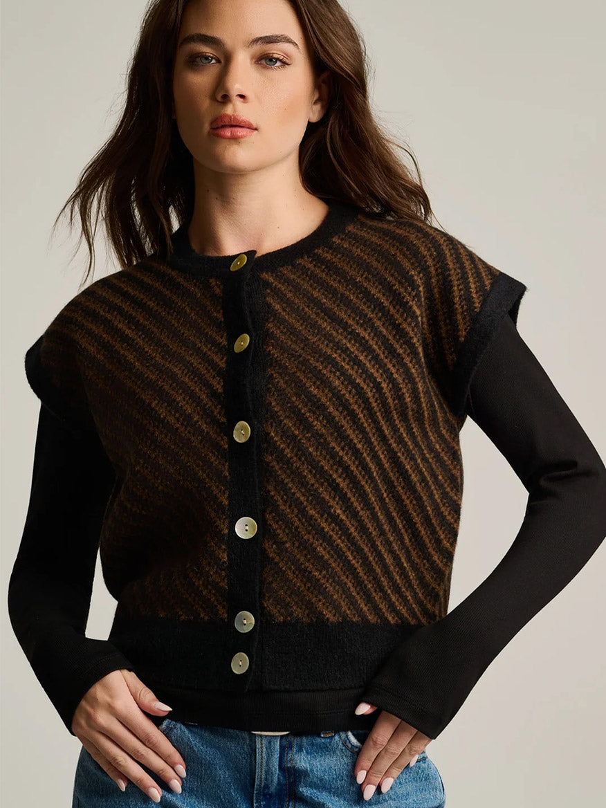 A woman wearing a Lisa Todd In Vest in Black Combo, featuring a sleeveless, black and brown diagonal striped button-down over a long-sleeved black top for modern layering.