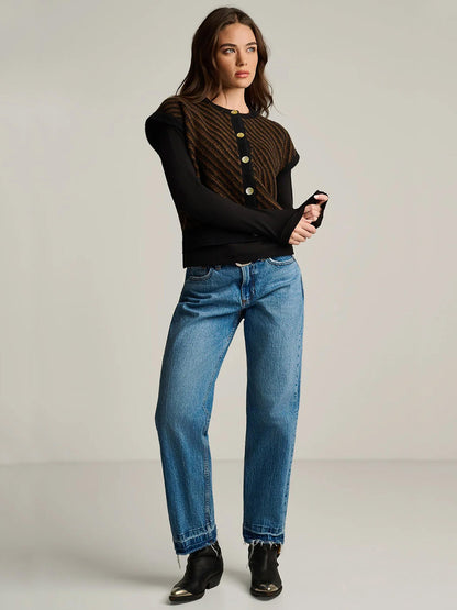 A person wearing a Lisa Todd In Vest in Black Combo over a black long-sleeve top, blue jeans, and black ankle boots with metallic toe caps.