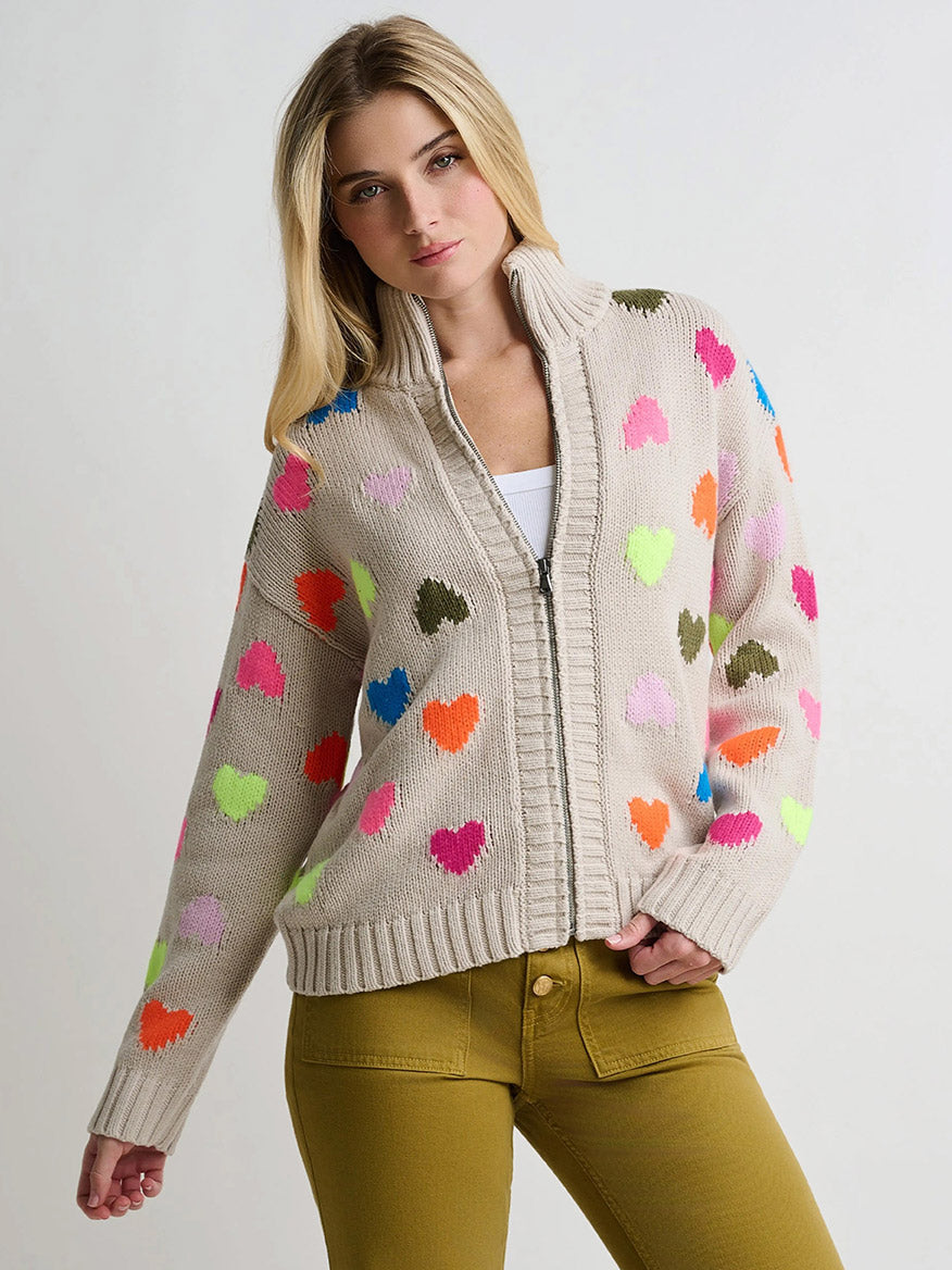 Lisa Todd Love Zip Cardigan in Chickpea, an oversized beige zip-up cardigan featuring a pattern of colorful heart shapes.