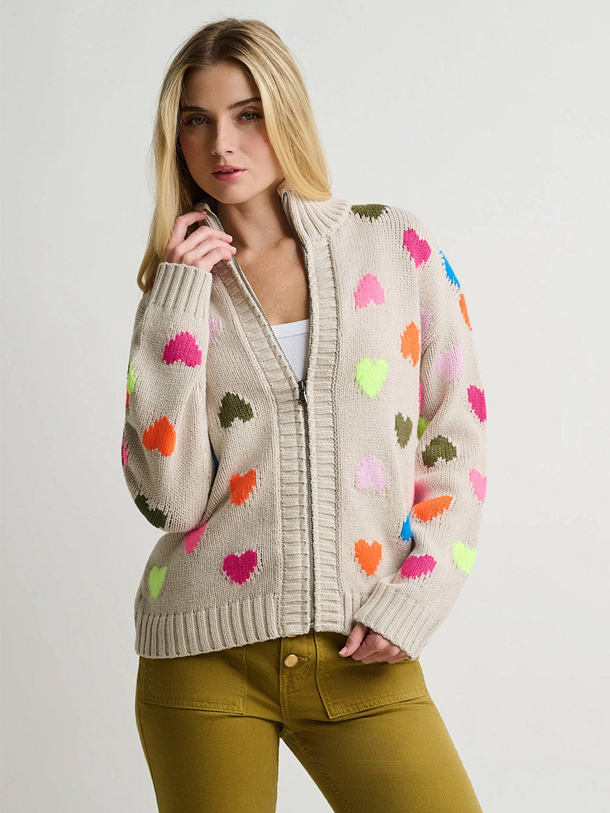 Lisa Todd Love Zip Cardigan in Chickpea: an oversized, beige zip-front knit cardigan featuring a pattern of small, multicolored neon hearts.