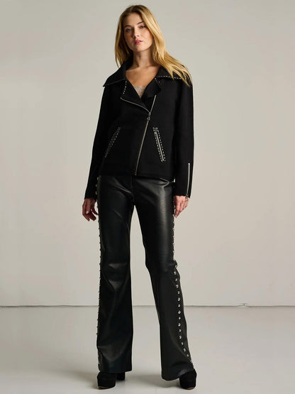 A woman wearing a Lisa Todd Moto Stitch Jacket in Black with white contrast stitching and matching trousers with silver side-seam embellishments.