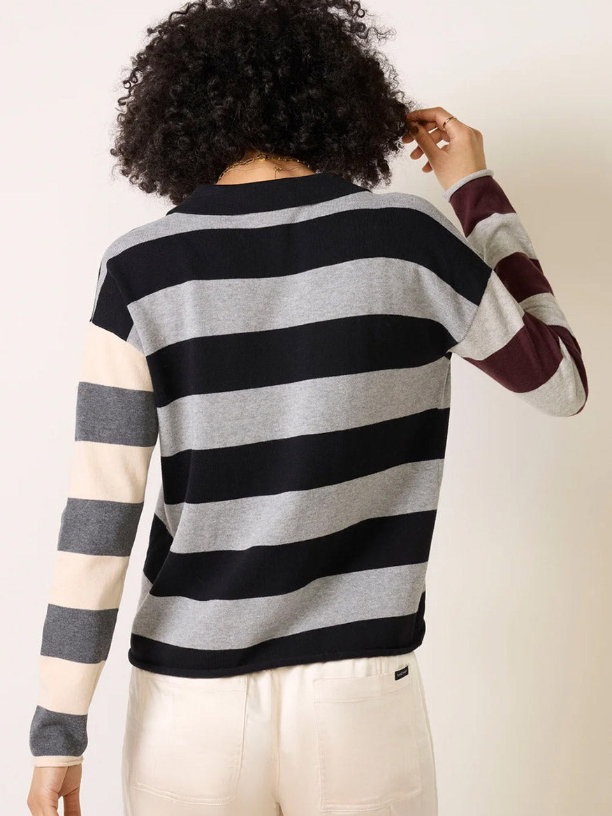 Back view of a person wearing a Lisa Todd Perfect Pitch Collared V in Black/Grey, featuring colorblock horizontal stripes in black, grey, and cream with contrast long sleeves.