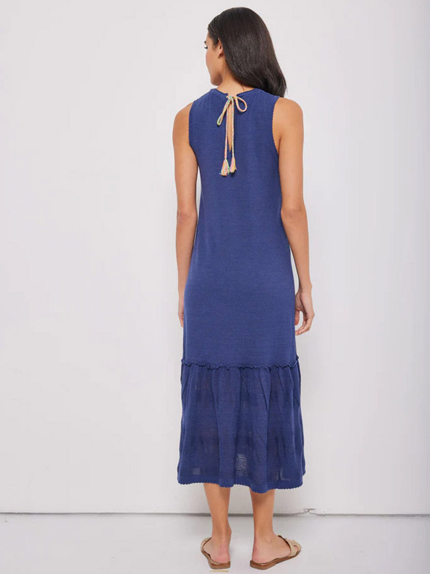 Woman in a Lisa Todd Shifty Dress in Indigo with a ruffled, flared bottom hem and contrast back ties.
