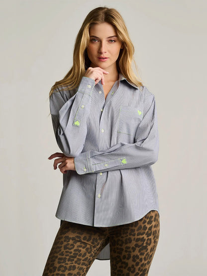Woman stands facing forward in the Lisa Todd Stripe It To Me shirt in black and white—an oversized fit button-down expertly tailored from cotton—with neon green patches, paired with brown leopard print leggings, against a plain light background.