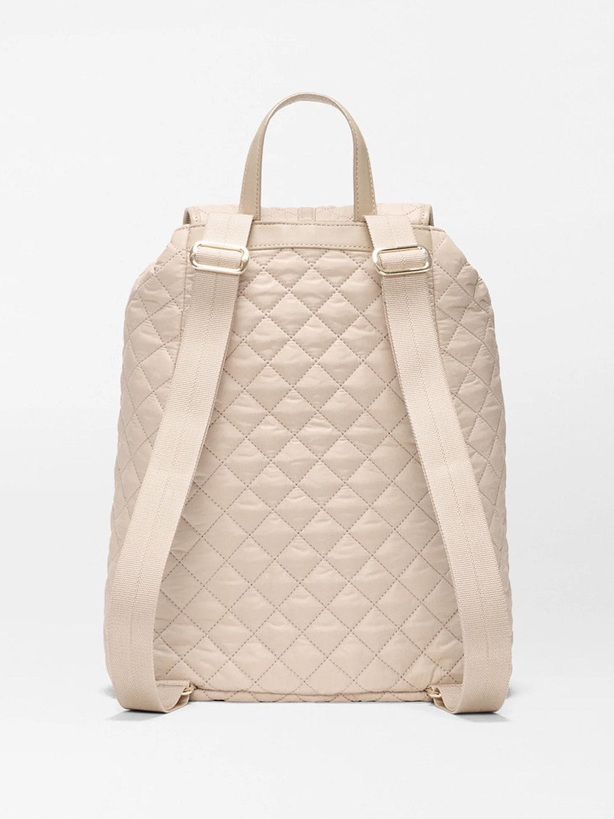 The MZ Wallace Astor Backpack in Buff Oxford is a beige quilted laptop backpack shown from the back, with padded straps, a top handle, and a diamond stitch pattern.