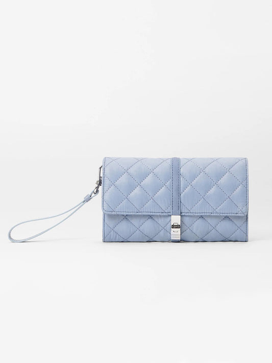 Part of the MZ Wallace Astor collection, this stone blue Oxford quilted clutch features a sleek wrist strap and silver clasp, elegantly crafted with REC nylon for a modern touch.