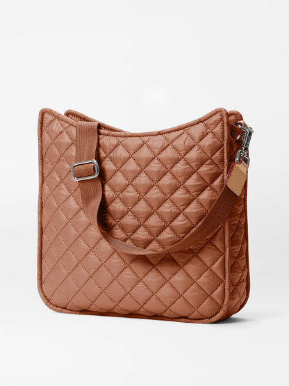 The MZ Wallace Metro Box Crossbody in Terracotta Oxford, a quilted brown shoulder bag with an adjustable strap, ideal as a lightweight crossbody option, is displayed against a plain background.