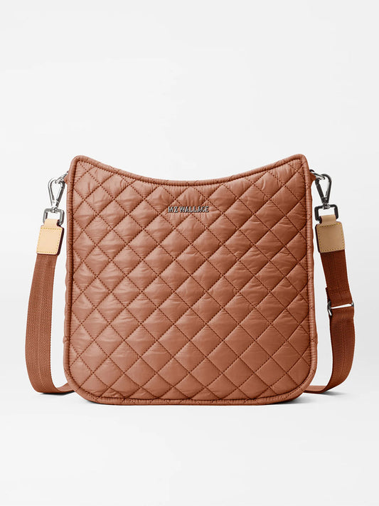 The MZ Wallace Metro Box Crossbody in Terracotta Oxford features brown quilting, an adjustable strap, and silver hardware, blending elegance and functionality for any occasion.