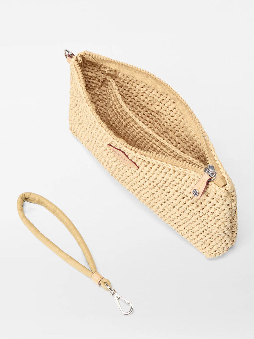 The MZ Wallace Crochet Clutch in Crochet/Camel features a woven beige design with a zip closure and a detachable light tan wrist strap, displayed on a white surface. Its open interior compartments make it perfect for carrying essentials in style.