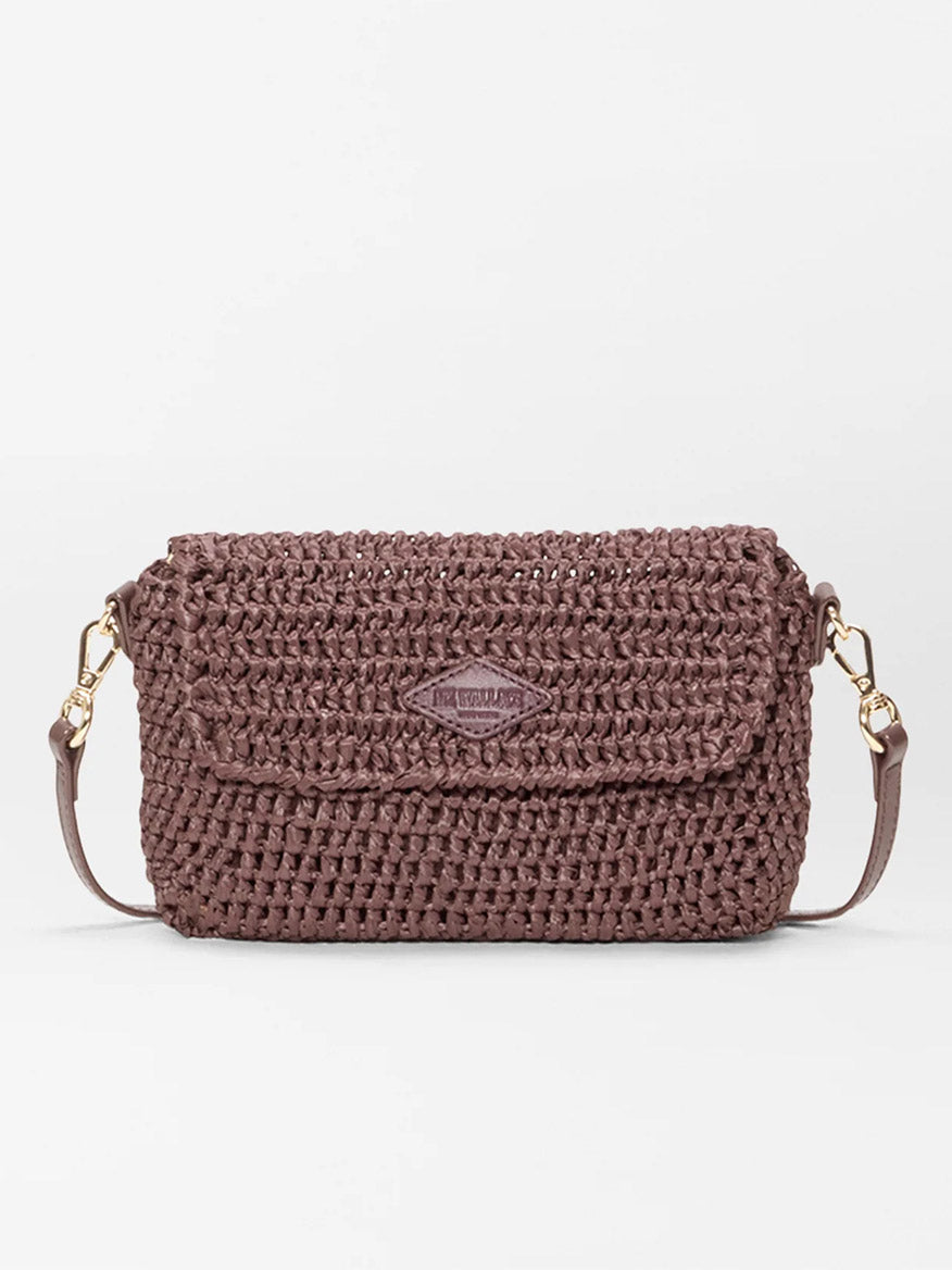 The MZ Wallace Crochet Convertible Crossbody in brown crochet, a small rectangular shoulder bag with flap closure, gold hardware, and adjustable strap, is shown against a plain white background.