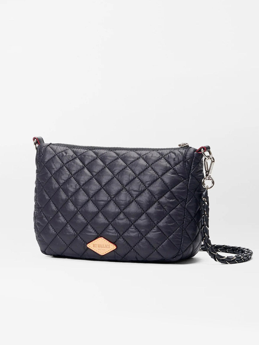 The MZ Wallace Crosby Ella Crossbody in Black Oxford is a quilted handbag made from Italian leather, complete with an adjustable chain strap and a sleek metal logo on the front.