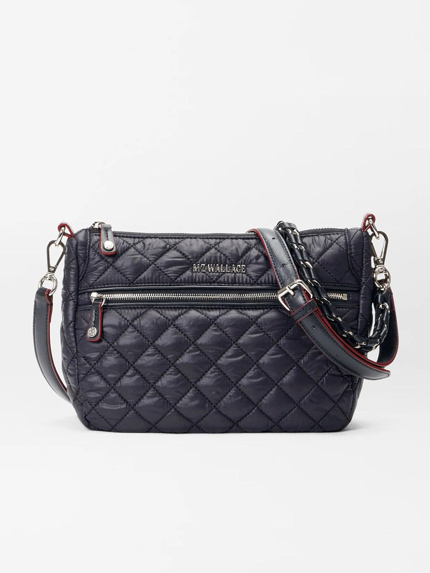 Introducing the MZ Wallace Crosby Ella Crossbody in Black Oxford, a luxurious quilted bag crafted from premium Italian leather. It features silver hardware and striking red accents, along with a front zipper and an adjustable strap for exceptional versatility.