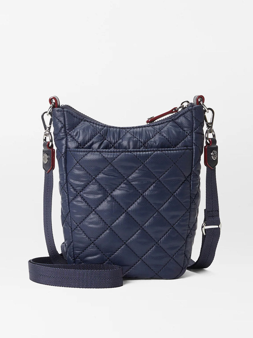 A small, dark blue quilted crossbody bag with Italian leather trim and a detachable adjustable strap on a plain white background, MZ Wallace Crosby Go in Dawn Oxford.