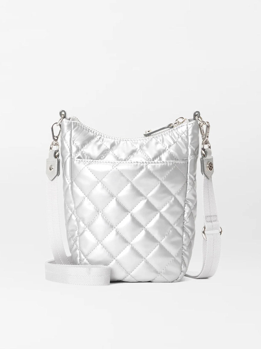 The MZ Wallace Crosby Go in Matte Silver Oxford is a small, quilted metallic silver crossbody bag with a white strap and a zipper closure. The detachable straps add versatility to this chic accessory, reminiscent of the classic Crosby Go tote.