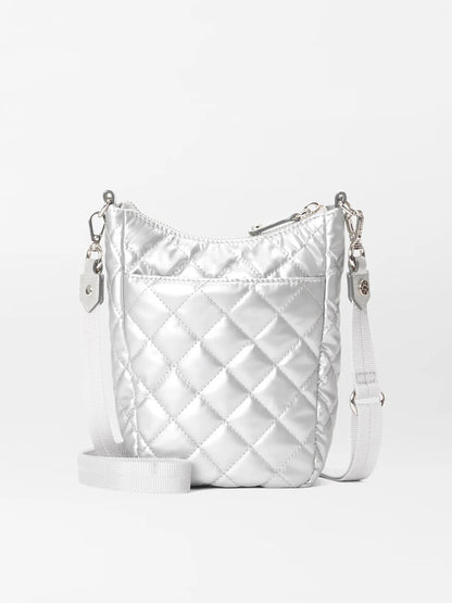 The MZ Wallace Crosby Go in Matte Silver Oxford is a small, quilted metallic silver crossbody bag with a white strap and a zipper closure. The detachable straps add versatility to this chic accessory, reminiscent of the classic Crosby Go tote.