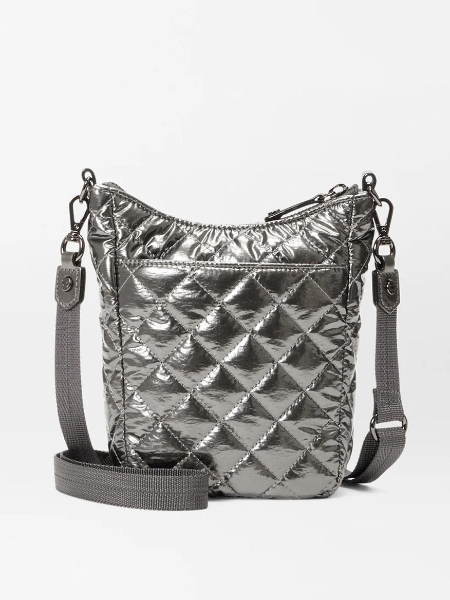 The MZ Wallace Crosby Go in Pewter Metallic Oxford is a quilted handbag featuring diamond pattern stitching. It is accented with Italian leather trim and includes a zip closure along with a long, adjustable crossbody strap for versatile wear.