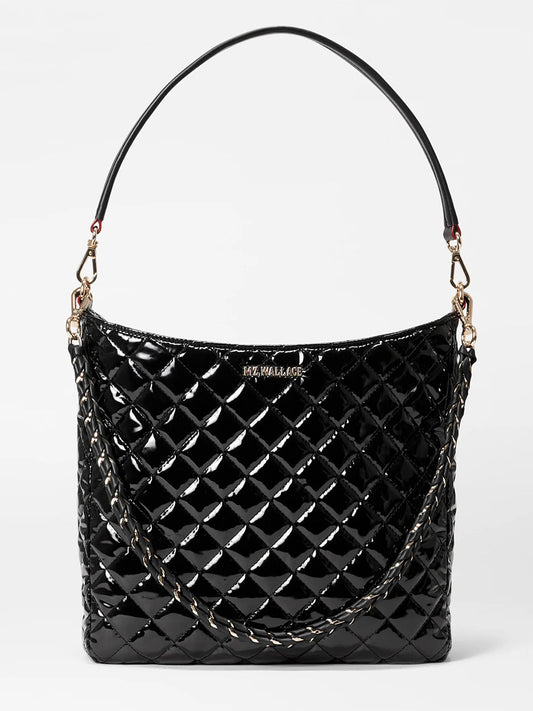 An MZ Wallace Crosby Hobo in Black Lacquer Oxford featuring quilted patent leather with gold-tone hardware, a single strap, and chain detailing on the sides.