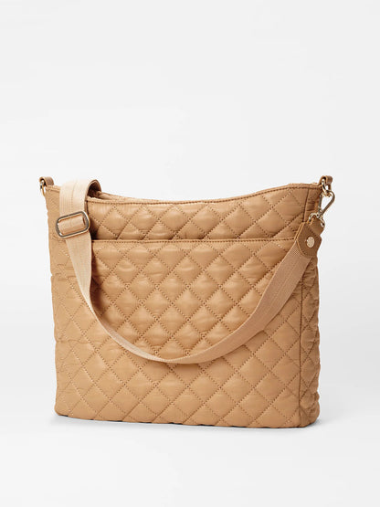 The MZ Wallace Crosby Hobo in Caramel Oxford boasts a luxurious quilted design with an adjustable strap and gold hardware against a plain white background, crafted from Italian leather.