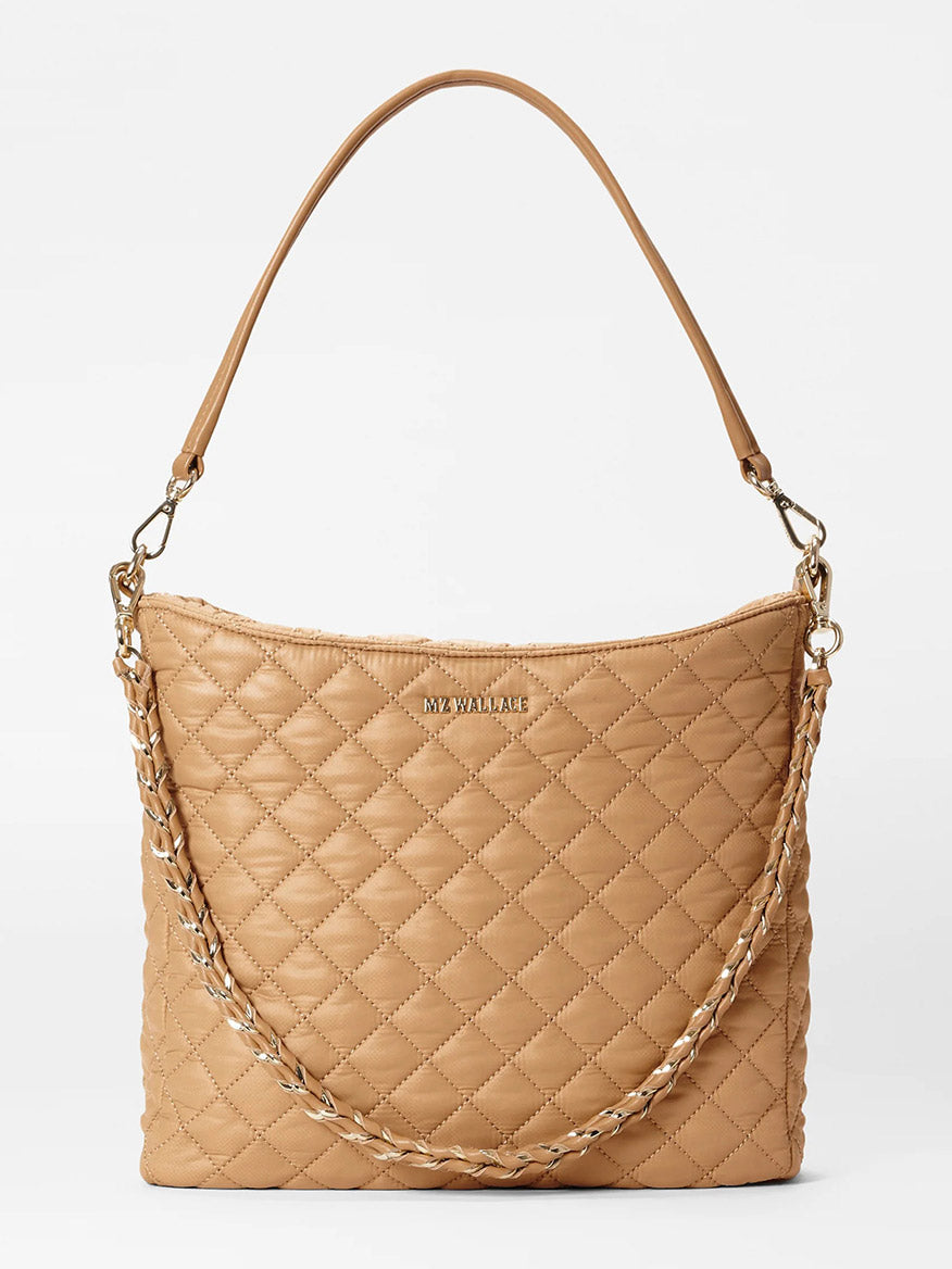 The MZ Wallace Crosby Hobo in Caramel Oxford is a quilted handbag that elegantly combines Italian leather with chain-linked straps against a plain background.