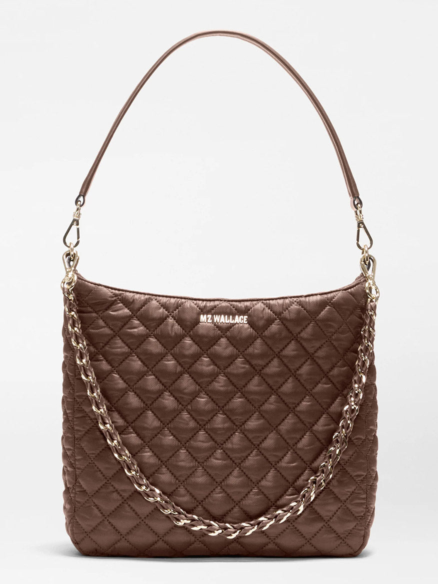 The MZ Wallace Crosby Hobo in Walnut Oxford is a brown quilted handbag with a short shoulder strap and a decorative gold chain, featuring “MZ WALLACE” branding on the front—crafted in the brand’s signature style from premium recycled Oxford nylon for lasting durability.