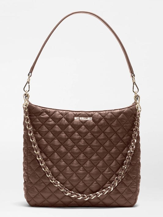The MZ Wallace Crosby Hobo in Walnut Oxford is a brown quilted handbag with a short shoulder strap and a decorative gold chain, featuring “MZ WALLACE” branding on the front—crafted in the brand’s signature style from premium recycled Oxford nylon for lasting durability.