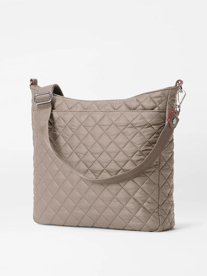 The MZ Wallace Crosby Hobo in Morning Dove Oxford is a taupe quilted shoulder bag with Italian leather accents, silver hardware, a wide strap, and a rectangular shape, shown on a plain white background.