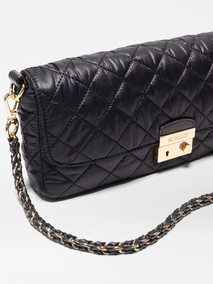 Black MZ Wallace Crosby Lock Baguette in Black Oxford featuring a quilted design, gold-tone metal lock closure, and a chain-link shoulder strap.