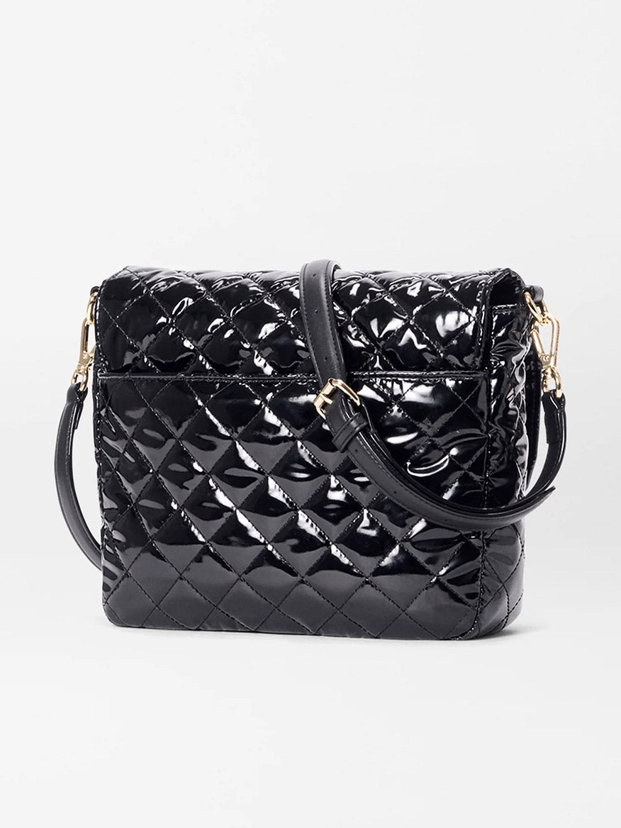 The MZ Wallace Crosby Lock Medium Crossbody in Black Lacquer Oxford features quilted patent leather, a gold lock and key closure, and an adjustable strap, shown against a plain white background.