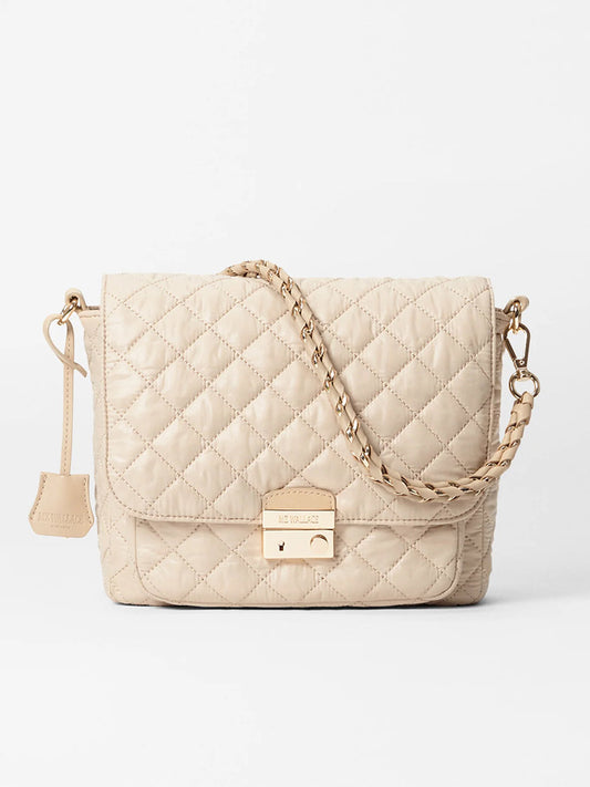 The MZ Wallace Crosby Lock Medium Crossbody in Buff Oxford is styled against a white background, featuring quilted nylon detail, a chain strap, and a gold clasp.