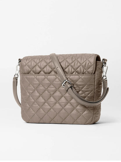 The MZ Wallace Crosby Lock Medium Crossbody in Morning Dove Oxford, featuring quilted taupe nylon with a diamond pattern, silver hardware, and an adjustable strap, is showcased as a stylish crossbody against a white background.