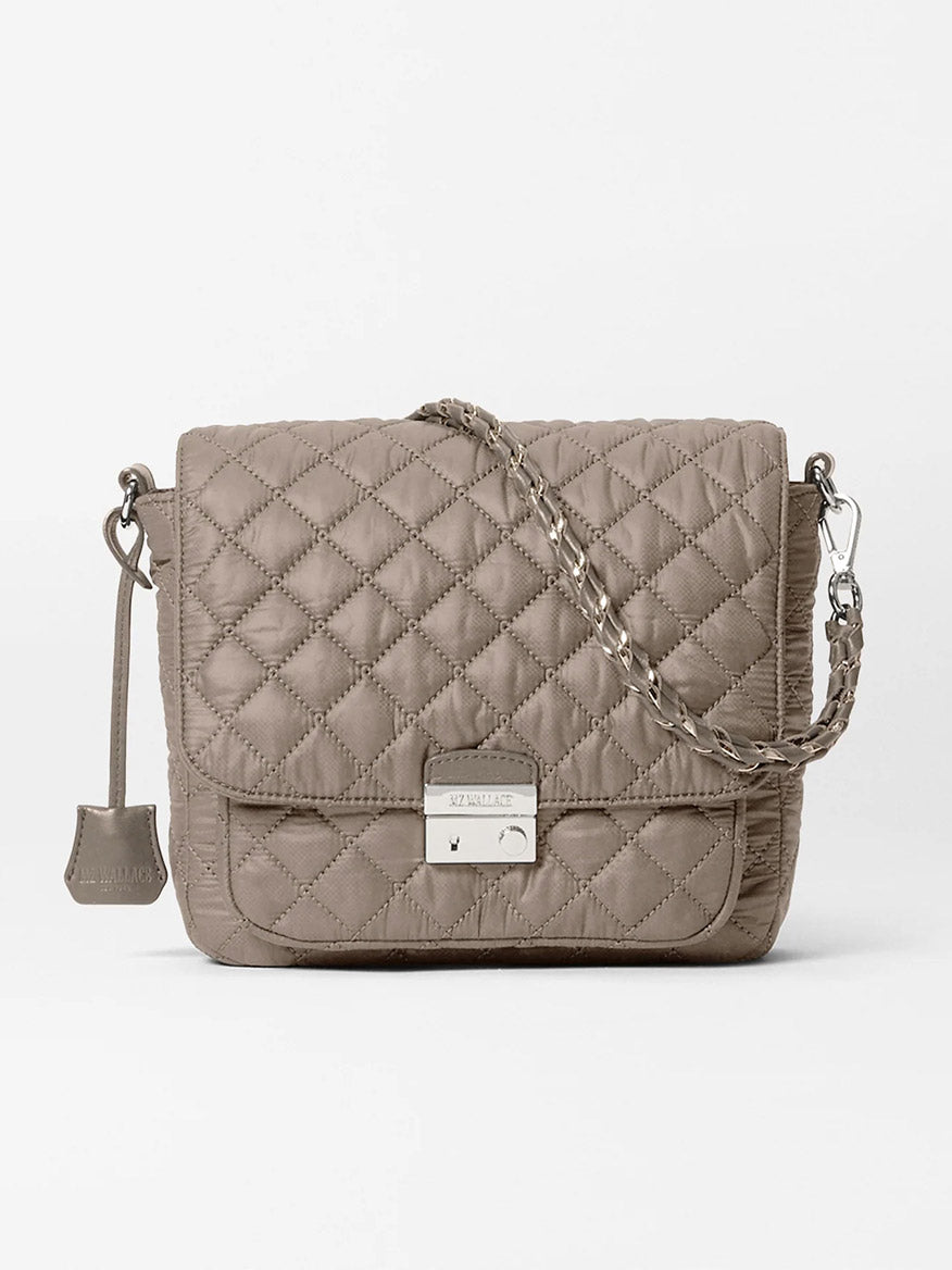 MZ Wallace Crosby Lock Medium Crossbody in Morning Dove Oxford, featuring a quilted design, chain and leather strap, front flap closure, and silver-tone lock and tag accents, displayed on a plain white background.