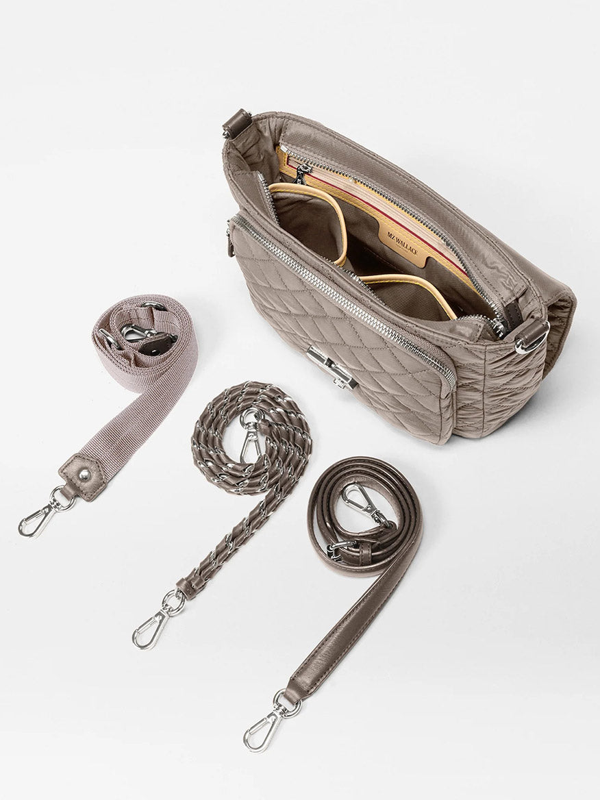 The MZ Wallace Crosby Lock Medium Crossbody in Morning Dove Oxford, a nylon quilted designer bag, features three detachable straps—fabric, braided, and smooth leather—and comes with a pair of sunglasses inside.