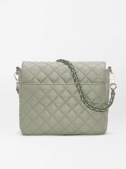 The MZ Wallace Crosby Lock Medium Crossbody in Agave Green Oxford is a quilted designer bag with a braided strap and silver hardware, shown against a plain white background.
