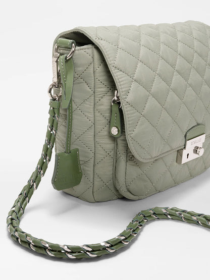 The MZ Wallace Crosby Lock Medium Crossbody in Agave Green Oxford is a quilted nylon handbag with a metal clasp, chain-and-leather strap, and hanging tag, displayed on a plain white background.