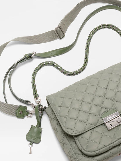 An MZ Wallace Crosby Lock Medium Crossbody in Agave Green Oxford, featuring quilted nylon, a silver clasp, braided shoulder strap, canvas crossbody strap, and key charm, shown on a white background.