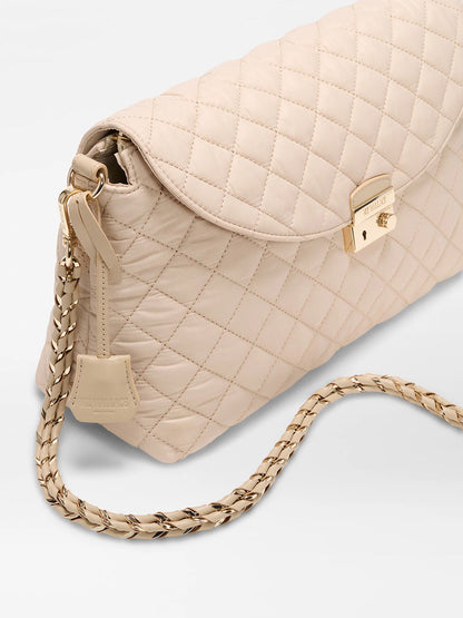 The MZ Wallace Crosby Lock Shoulder in Buff Oxford is a beige quilted Italian leather handbag with a gold clasp, gold-and-leather chain strap, and interchangeable straps for versatile styling, shown on a light background.
