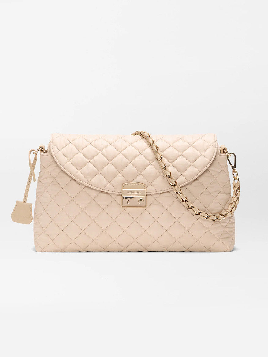 The MZ Wallace Crosby Lock Shoulder in Buff Oxford features beige quilted Italian leather, a gold chain strap, flap closure, and gold-tone clasp, shown against a plain white background.