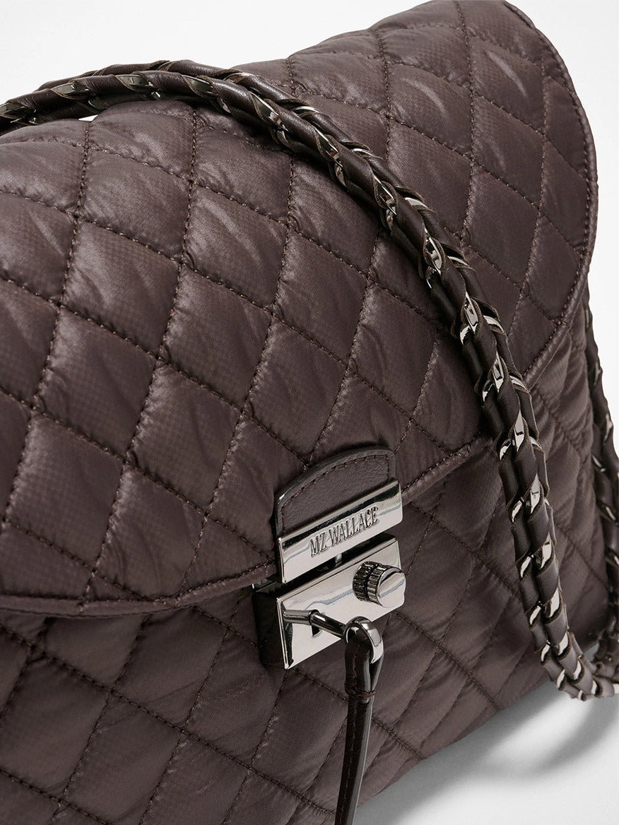 Close-up of the MZ Wallace Crosby Lock Shoulder in Espresso Oxford, featuring quilted dark brown leather, chain strap, silver clasp engraved "MZ WALLACE," and a secure zip top closure.