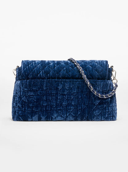 The MZ Wallace Crosby Lock Shoulder in Midnight Velvet, featuring a blue quilted velvet body, Italian leather trim, and a silver chain strap, is displayed against a plain white background.