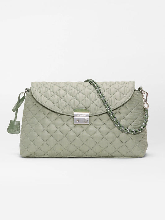 The MZ Wallace Crosby Lock Shoulder in Agave Green Oxford features a quilted design, flap closure with silver lock, Italian leather trim, and a matching chain strap, showcased against a plain white background.