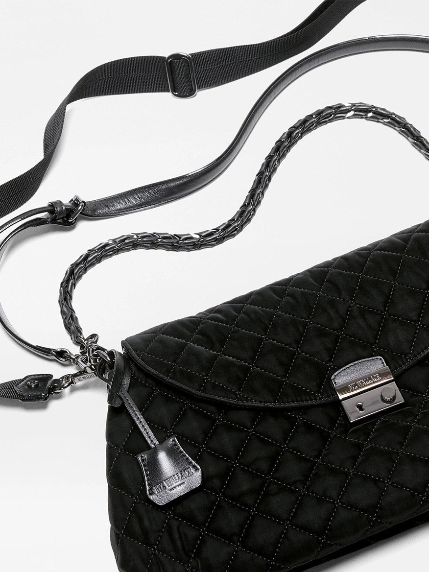 Black MZ Wallace Crosby Lock Shoulder in Black Velvet Finish bag featuring a metal closure, braided leather handle, and an adjustable nylon crossbody strap.