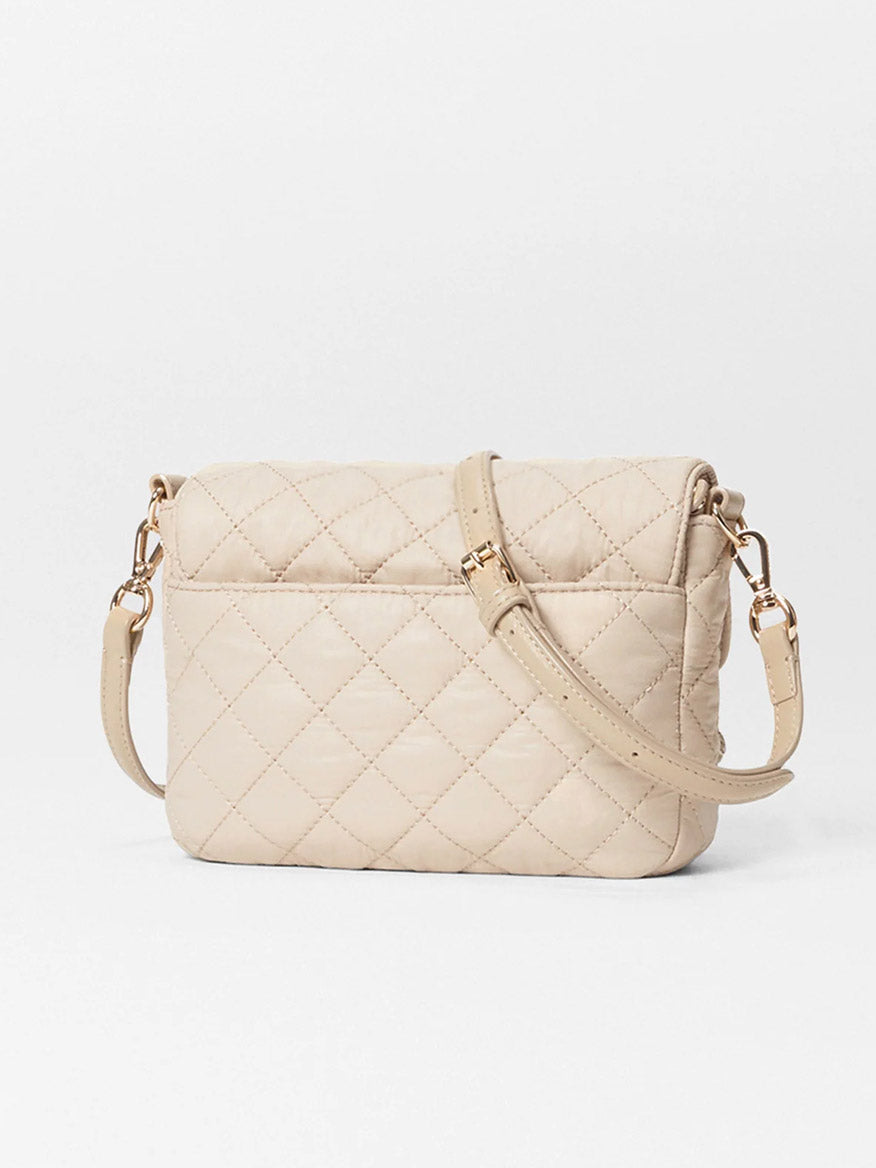 The MZ Wallace Crosby Lock Small Crossbody in Buff Oxford, a designer beige quilted bag with Italian leather trim and gold-tone strap and zippers, is elegantly displayed against a plain white background.