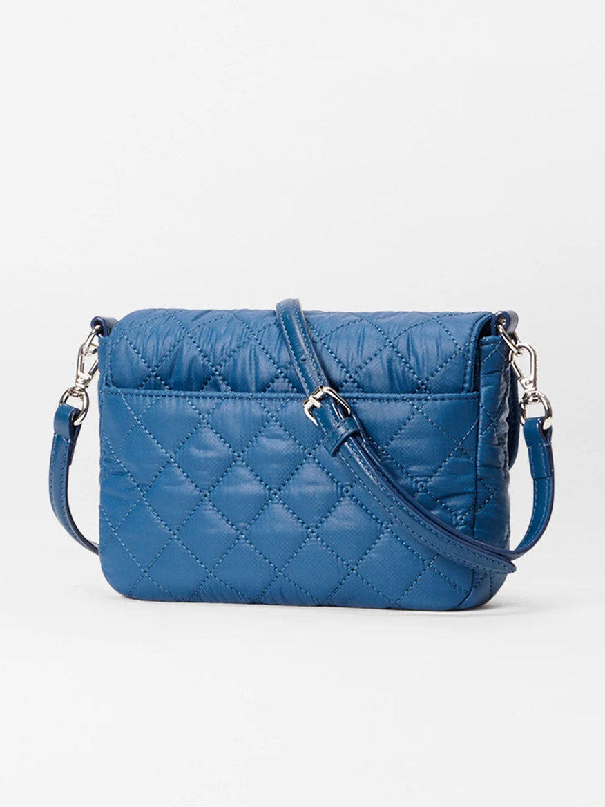 The MZ Wallace Crosby Lock Small Crossbody in French Blue Oxford features a quilted design, long adjustable strap, and silver hardware, shown against a plain white background.