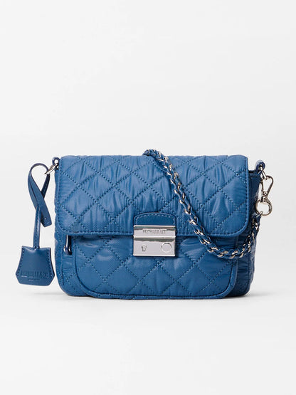 The MZ Wallace Crosby Lock Small Crossbody in French Blue Oxford features quilted leather, a silver chain strap, front flap with metal clasp, and a matching key pouch.