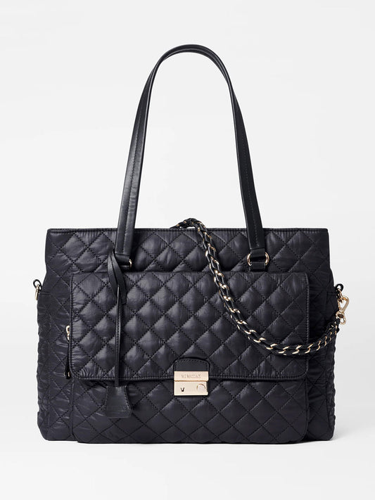 The MZ Wallace Crosby Lock Tote in Black Oxford, featuring a gold chain strap, front pocket, and metal clasp, is photographed against a white background. This stylish accessory exudes the sophistication of a designer work bag for the modern professional.