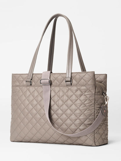 The MZ Wallace Crosby Lock Tote in Morning Dove Oxford is a taupe quilted bag with dual handles, a detachable shoulder strap, zip closure, and minimalist design.