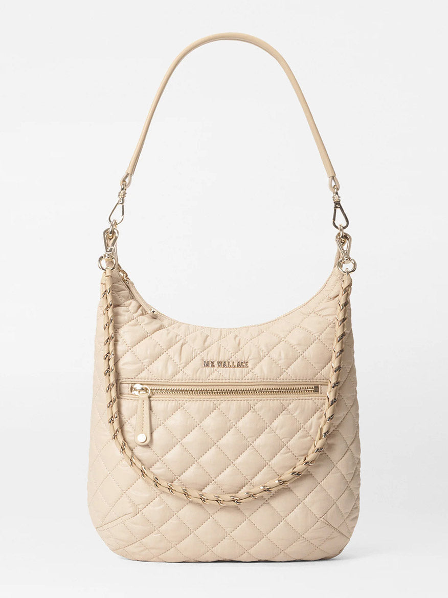 The MZ Wallace Crosby Sienna in Buff Oxford is a beige quilted handbag made from Italian leather, featuring a single strap and front zipper pocket, perfect for adding sophistication to any outfit.