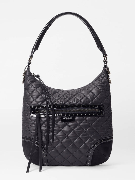 The MZ Wallace Multi Stud Crosby Sienna in Black Stud & Suede is a black quilted shoulder bag featuring a top handle, front zippered pocket, decorative studs, suede details, fabric tassel accent, and an adjustable shoulder strap.