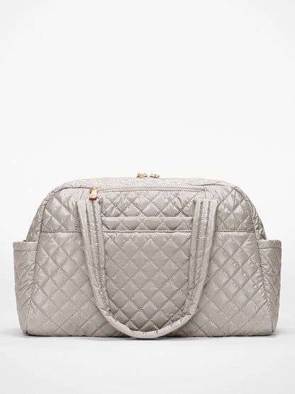 The MZ Wallace Jimmy Deluxe in Sable Pearl Metallic, featuring gray quilted design, Italian leather trim, dual handles, gold zipper, and side pockets, is displayed against a plain white background.