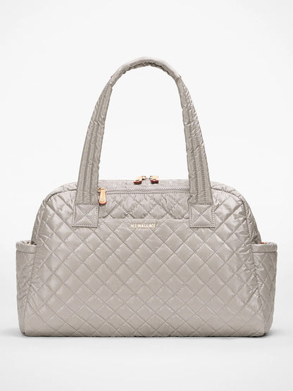 The MZ Wallace Jimmy Deluxe in Sable Pearl Metallic is a light gray quilted handbag with double handles, Italian leather trim, side pockets, and gold-tone zipper and logo, shown against a plain white background.